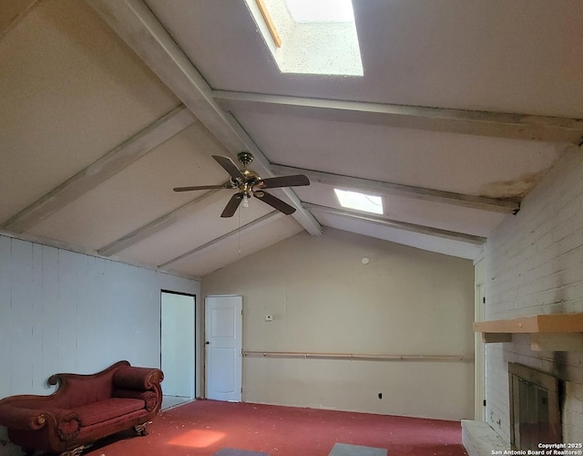 unfurnished room featuring a ceiling fan, a brick fireplace, and vaulted ceiling with beams