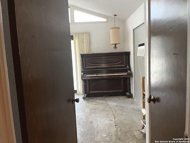 hall featuring unfinished concrete flooring and vaulted ceiling