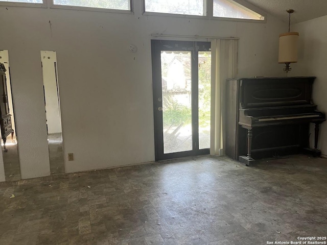 unfurnished living room with healthy amount of natural light and vaulted ceiling