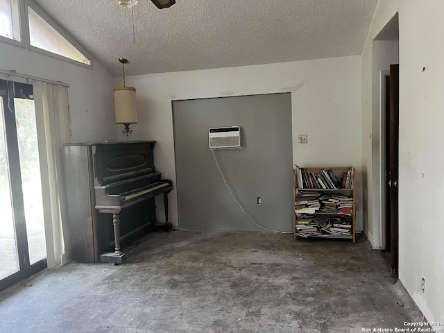 living area with plenty of natural light, a textured ceiling, a ceiling fan, lofted ceiling, and a wall mounted AC