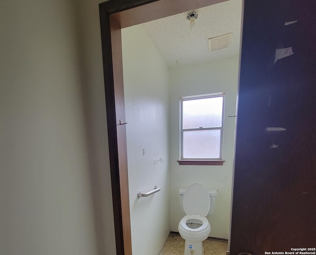 bathroom with toilet, baseboards, visible vents, and a textured ceiling