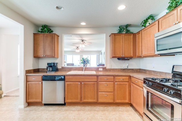 kitchen with stainless steel appliances, a sink, a ceiling fan, recessed lighting, and a textured ceiling
