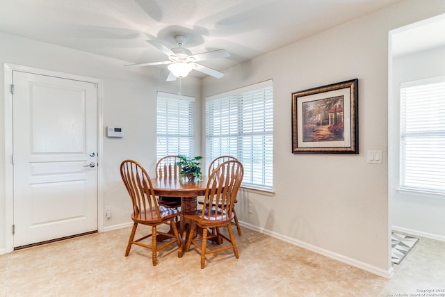 dining space with ceiling fan and baseboards