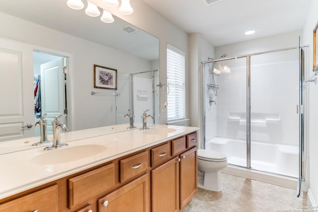 bathroom featuring a stall shower, tile patterned floors, double vanity, and toilet