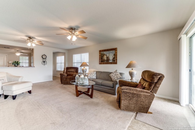 living area with carpet floors, healthy amount of natural light, ceiling fan, and baseboards