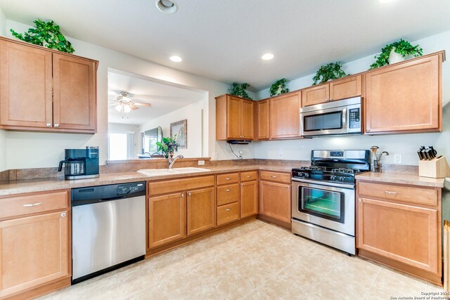 kitchen with appliances with stainless steel finishes, a sink, recessed lighting, light countertops, and ceiling fan