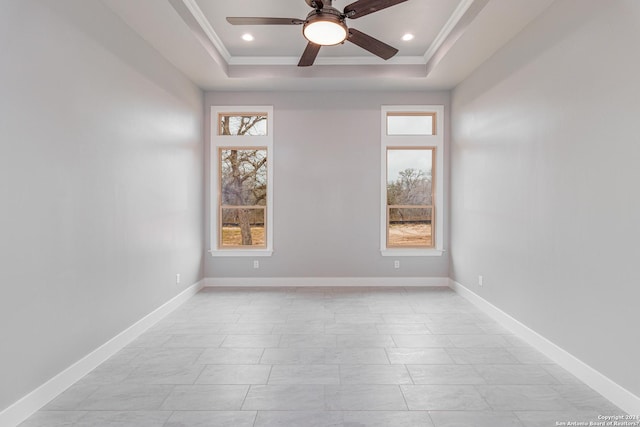 spare room with ornamental molding, recessed lighting, a ceiling fan, a tray ceiling, and baseboards