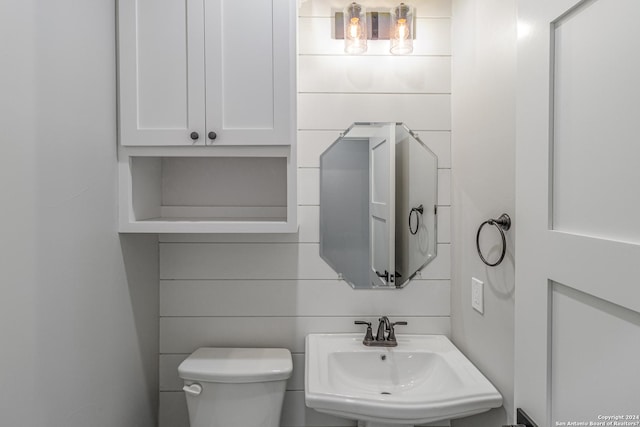 half bathroom featuring toilet and a sink