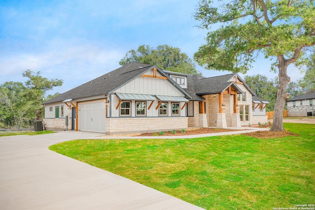 modern inspired farmhouse featuring central air condition unit, stone siding, driveway, a front lawn, and board and batten siding