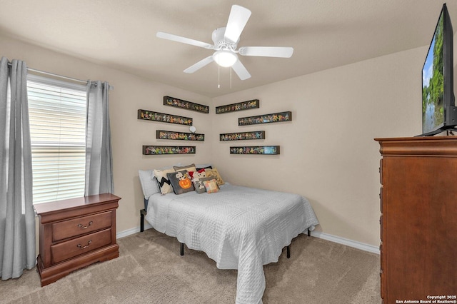 bedroom with light colored carpet, baseboards, and ceiling fan