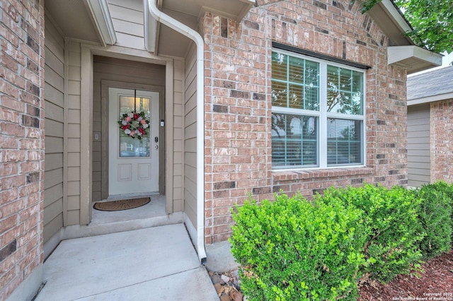 entrance to property featuring brick siding