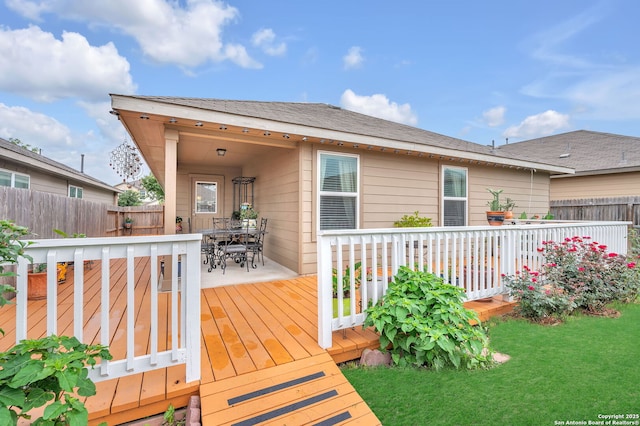 wooden deck featuring a yard, fence, and outdoor dining space