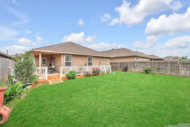 back of property with a fenced backyard, a wooden deck, and a yard