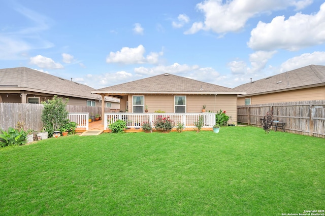 rear view of property featuring a yard, a wooden deck, and a fenced backyard
