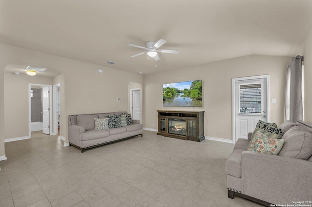 living room featuring arched walkways, a healthy amount of sunlight, visible vents, and a ceiling fan