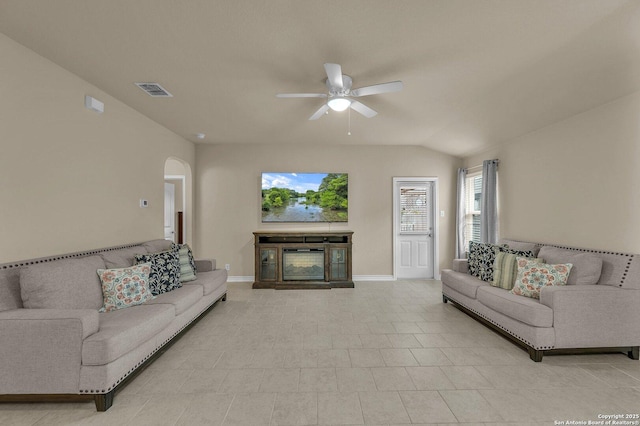 living room with plenty of natural light, baseboards, a ceiling fan, and arched walkways