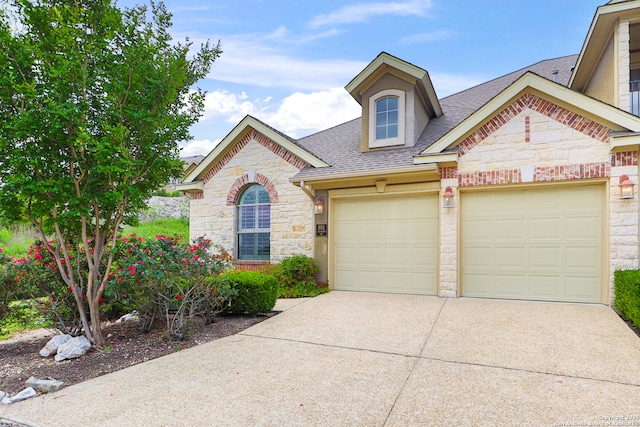 8250 Cruiseship Bay Unit, San Antonio, TX 78255 - view of front of house with stone siding, roof with shingles, an attached garage, and driveway