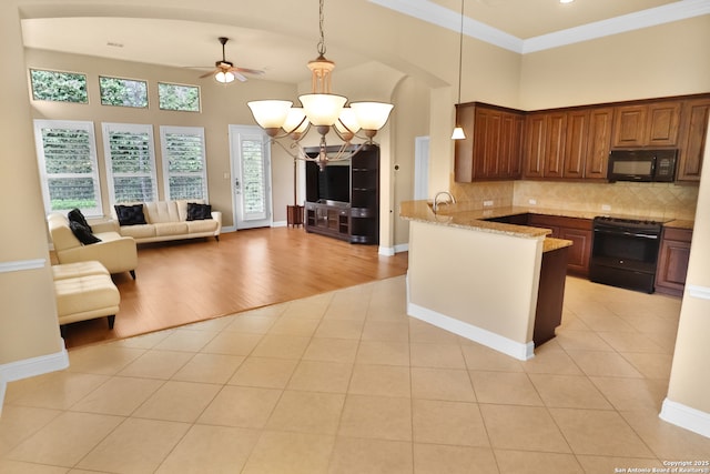 8250 Cruiseship Bay Unit, San Antonio, TX 78255 - kitchen with a peninsula, ceiling fan with notable chandelier, open floor plan, black appliances, and light stone counters