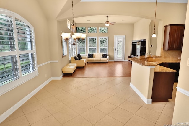 8250 Cruiseship Bay Unit, San Antonio, TX 78255 - kitchen featuring a peninsula, ceiling fan with notable chandelier, light stone counters, light tile patterned floors, and hanging light fixtures