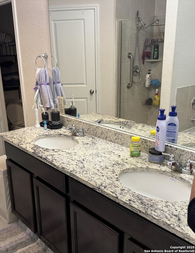 268 Cuban Emerald, San Antonio, TX 78253 - bathroom with a stall shower, double vanity, a sink, and a textured wall