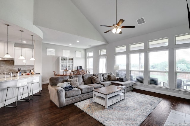 living area featuring ceiling fan, visible vents, a healthy amount of sunlight, and high vaulted ceiling