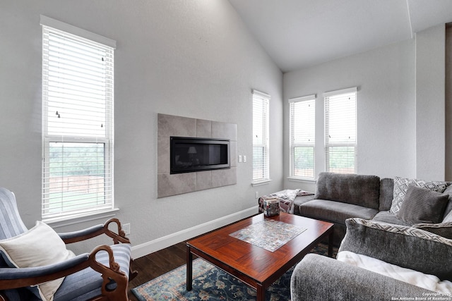 living room with vaulted ceiling, a fireplace, plenty of natural light, and wood finished floors