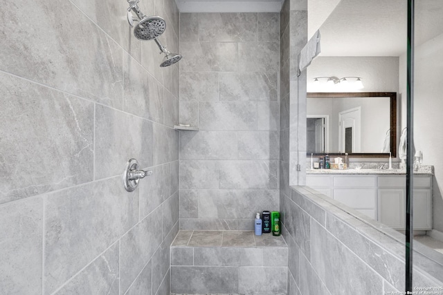 bathroom featuring vanity and tiled shower