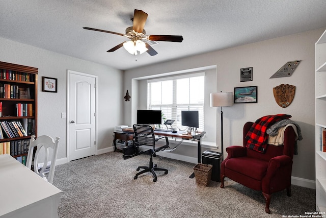 carpeted office featuring ceiling fan, a textured ceiling, and baseboards