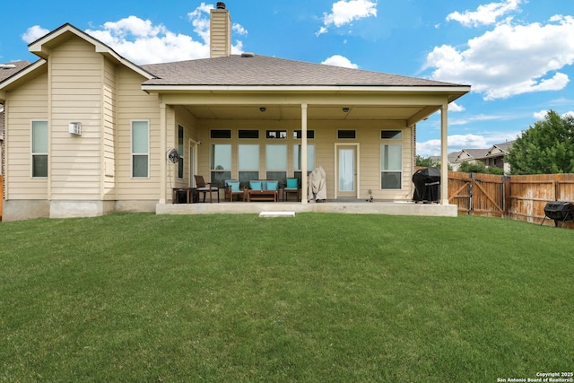 back of house with a fenced backyard, a patio area, an outdoor living space, and a lawn