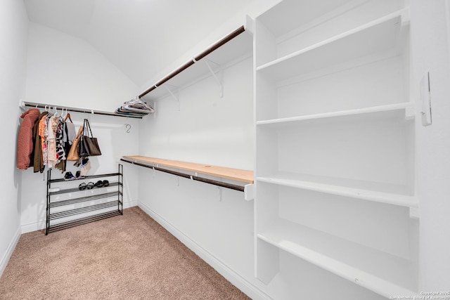 spacious closet featuring light colored carpet and vaulted ceiling