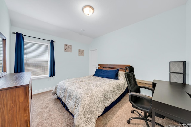 carpeted bedroom with vaulted ceiling and baseboards