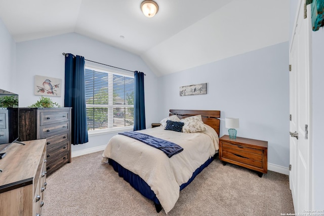 bedroom featuring vaulted ceiling, baseboards, and light carpet