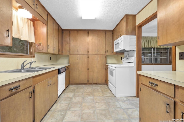 616 Ridgecrest, New Braunfels, TX 78130 - kitchen featuring a textured ceiling, white appliances, light countertops, and a sink