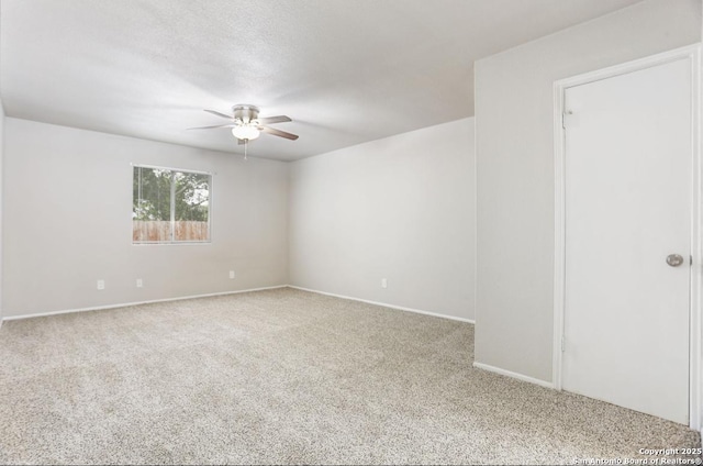 carpeted empty room featuring baseboards and a ceiling fan