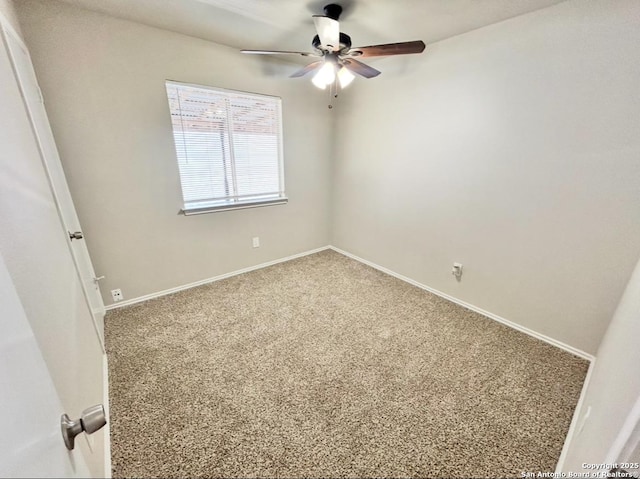 carpeted spare room with a ceiling fan and baseboards