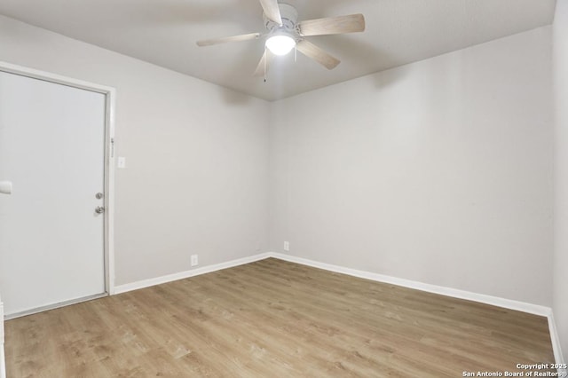 empty room featuring light wood finished floors, baseboards, and a ceiling fan