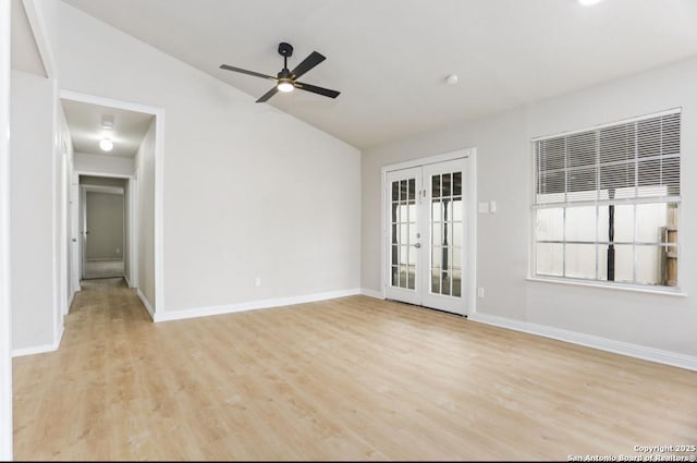 unfurnished room with baseboards, french doors, light wood-style flooring, and vaulted ceiling