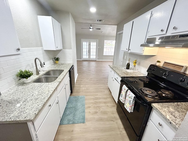kitchen with under cabinet range hood, visible vents, a sink, backsplash, and black appliances