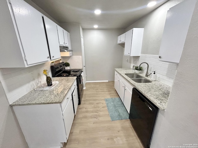 kitchen featuring a sink, tasteful backsplash, black appliances, under cabinet range hood, and light wood finished floors