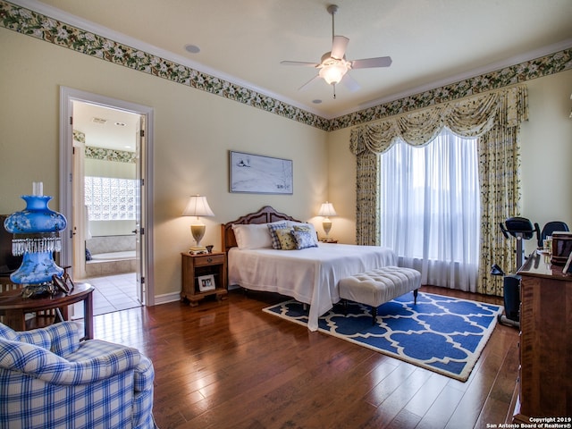 bedroom featuring ornamental molding, hardwood / wood-style flooring, ensuite bath, and baseboards