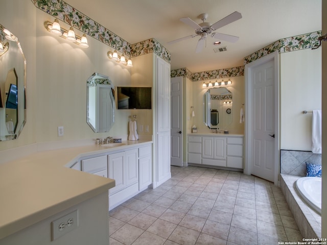 full bath featuring visible vents, tile patterned floors, tiled bath, a ceiling fan, and two vanities