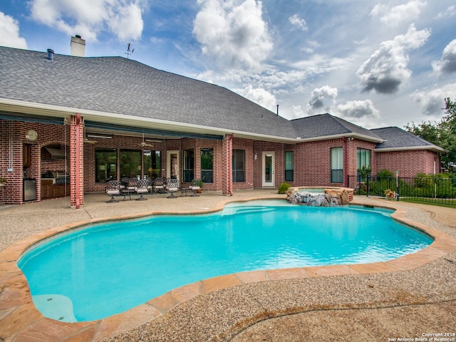 view of pool with a patio area, a pool with connected hot tub, and fence