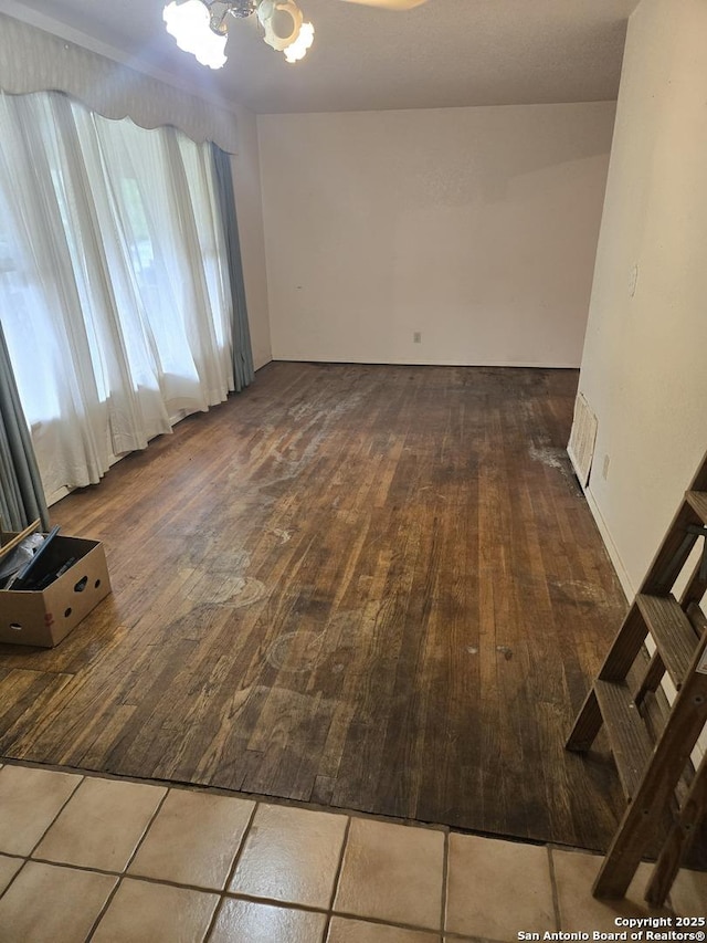 unfurnished room with a chandelier and hardwood / wood-style floors