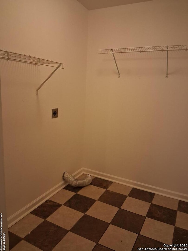 clothes washing area featuring laundry area, electric dryer hookup, and baseboards