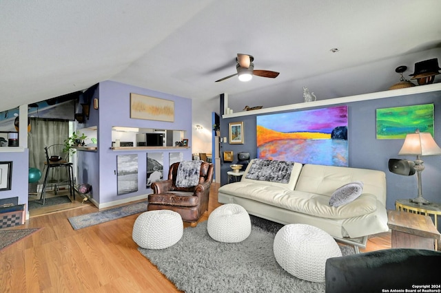 living room featuring a ceiling fan, vaulted ceiling, and wood finished floors