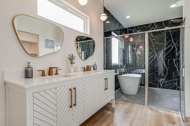 109 Hidden Hls, Floresville, TX 78114 - bathroom featuring a marble finish shower, a soaking tub, a sink, and wood finished floors