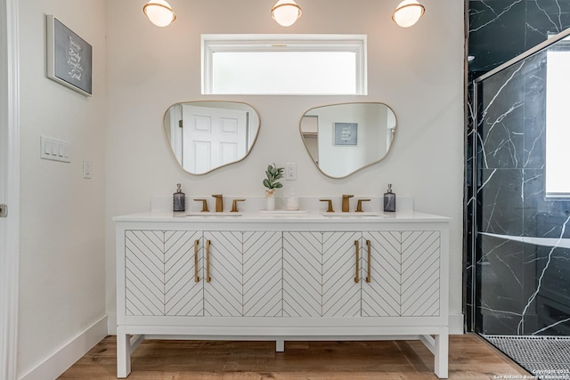 109 Hidden Hls, Floresville, TX 78114 - bathroom with a sink, double vanity, a marble finish shower, and wood finished floors