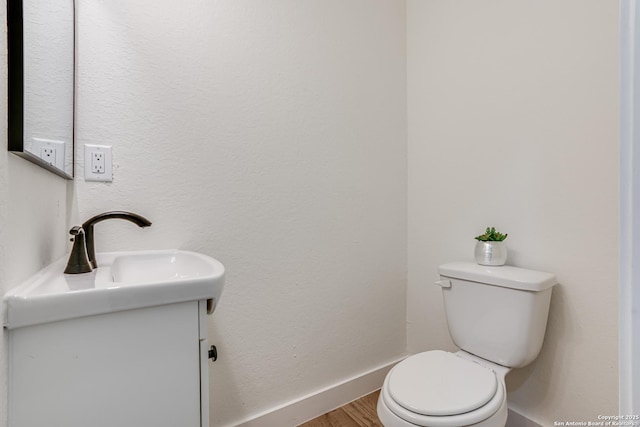 109 Hidden Hls, Floresville, TX 78114 - bathroom featuring vanity, toilet, baseboards, and wood finished floors