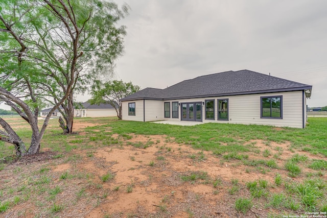 109 Hidden Hls, Floresville, TX 78114 - rear view of property featuring a shingled roof, french doors, and a lawn