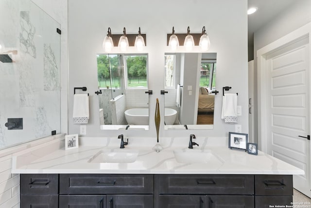 821 Bingham Ln, New Braunfels, TX 78132 - ensuite bathroom featuring double vanity, ensuite bath, a freestanding bath, and a sink